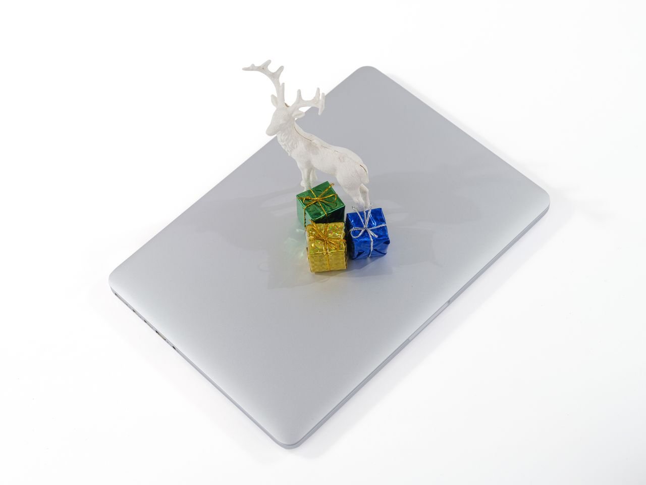 services-01 A festive reindeer figure with colorful gift boxes atop a laptop, symbolizing modern holiday celebrations.